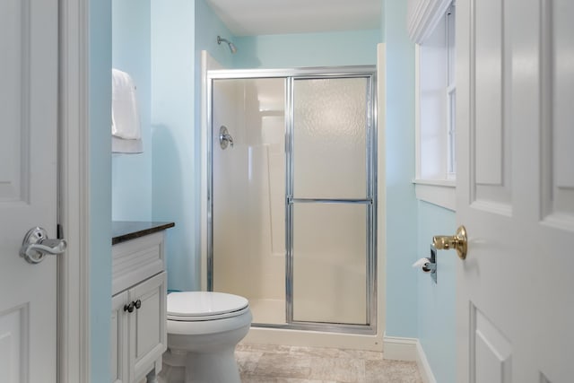 bathroom featuring vanity, toilet, and walk in shower