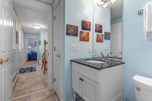 bathroom featuring a baseboard radiator, vanity, and toilet