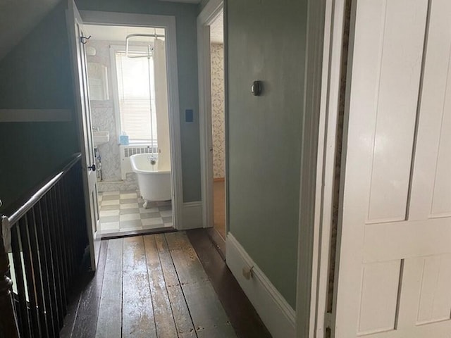 bathroom with a washtub and wood-type flooring