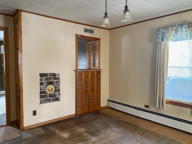 spare room with a baseboard heating unit, crown molding, and dark wood-type flooring