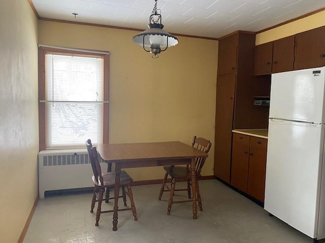 dining area with ornamental molding and radiator