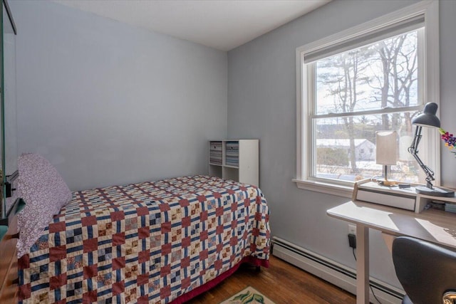 bedroom featuring a baseboard heating unit and dark hardwood / wood-style floors