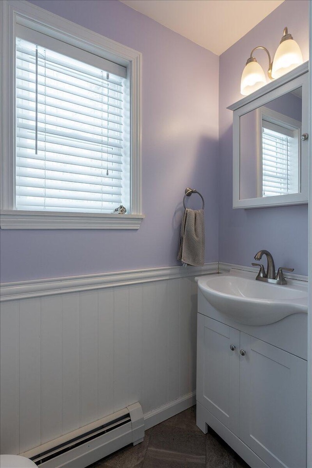 bathroom featuring vanity, a wealth of natural light, and baseboard heating