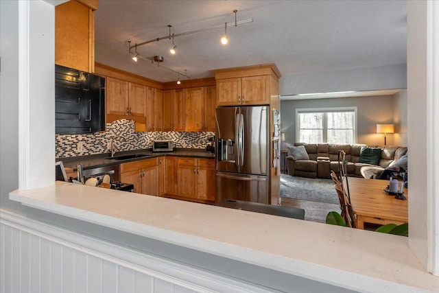 kitchen featuring tasteful backsplash, sink, stainless steel appliances, and kitchen peninsula