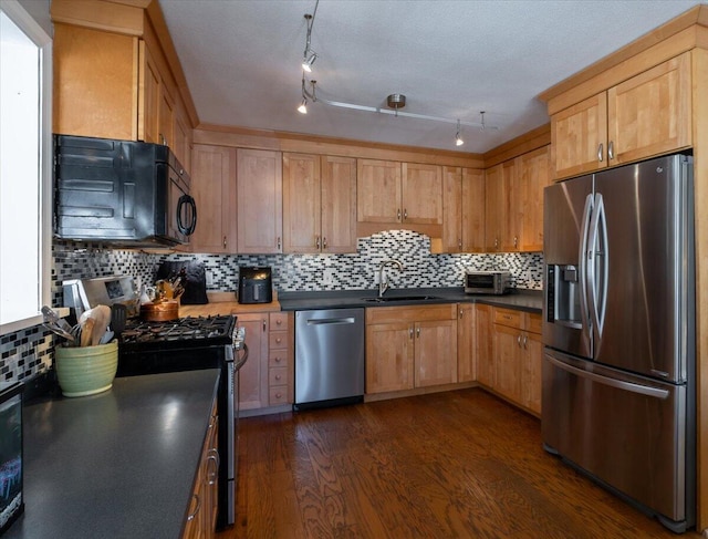 kitchen featuring dark hardwood / wood-style flooring, sink, tasteful backsplash, and stainless steel appliances