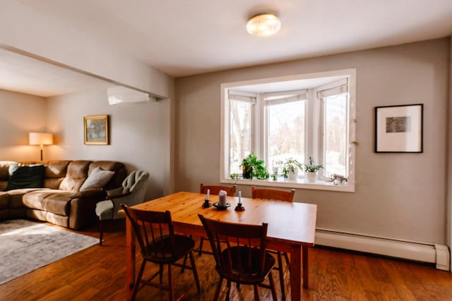 dining room with a baseboard radiator, dark hardwood / wood-style floors, and a wall unit AC