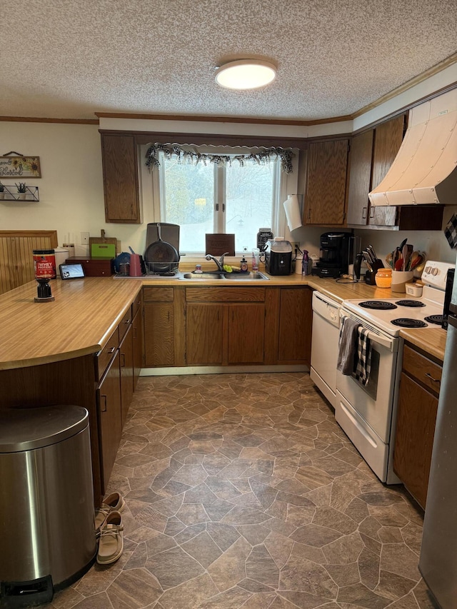 kitchen with extractor fan, sink, ornamental molding, white appliances, and a textured ceiling