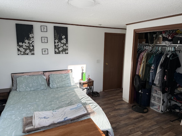 bedroom featuring crown molding, dark wood-type flooring, a closet, and a textured ceiling