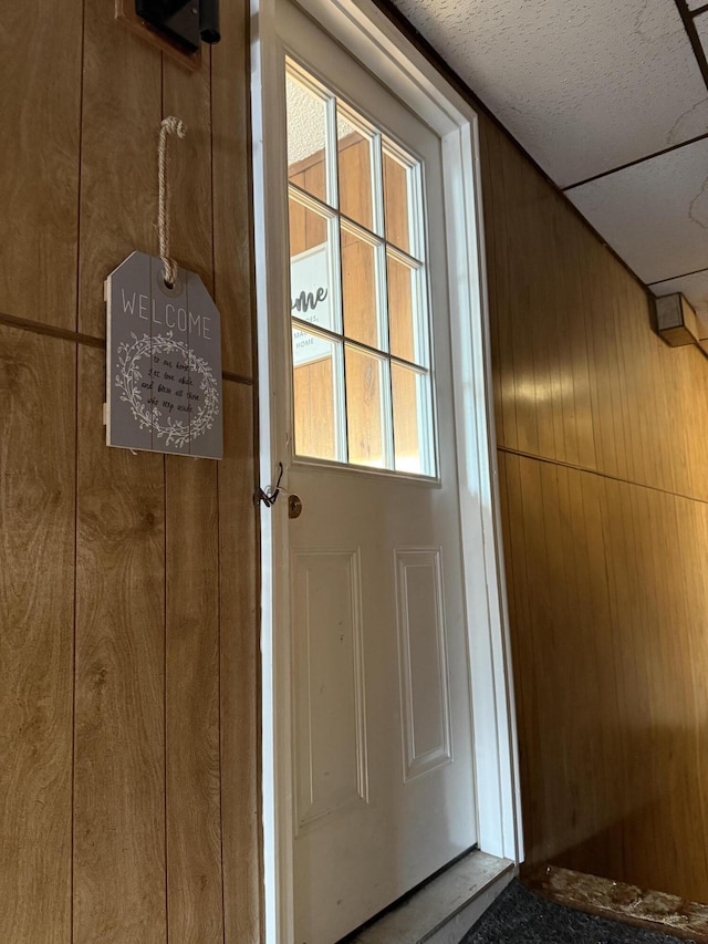 doorway featuring wood walls