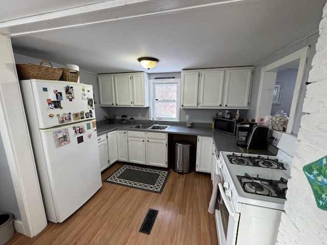 kitchen with white appliances, light hardwood / wood-style floors, sink, and white cabinets