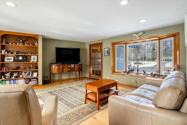 living room with recessed lighting, baseboards, and light wood-style floors