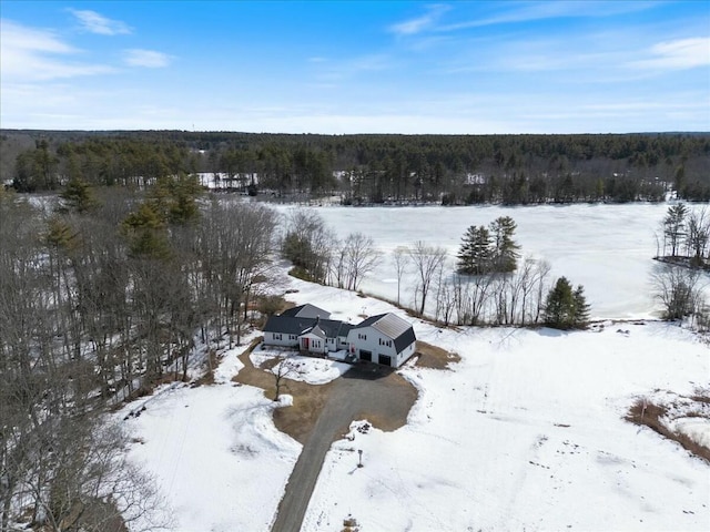 snowy aerial view with a wooded view