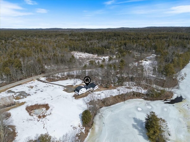 snowy aerial view featuring a forest view