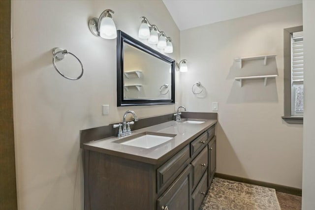 bathroom with a sink, baseboards, and double vanity