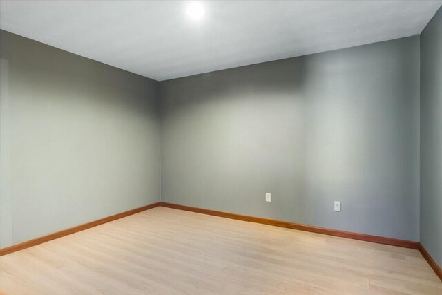 spare room with light wood-style floors and baseboards