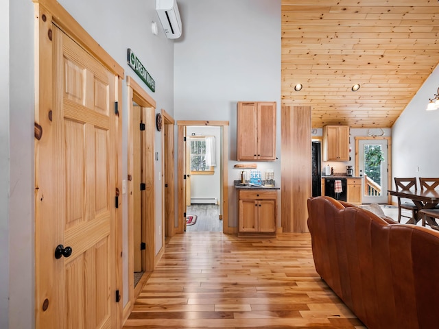 interior space featuring a baseboard heating unit, a wealth of natural light, an AC wall unit, and light wood-type flooring