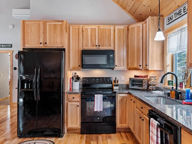 kitchen featuring an AC wall unit, pendant lighting, sink, dark stone counters, and black appliances