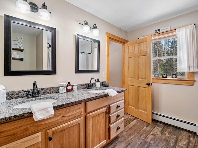 bathroom featuring a baseboard radiator, hardwood / wood-style floors, and vanity