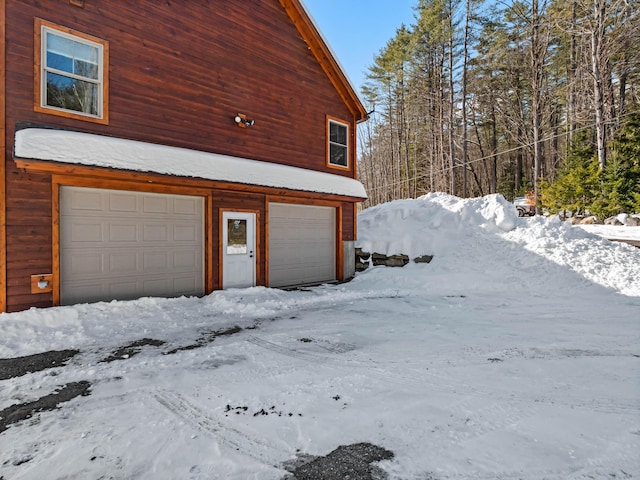 view of snow covered exterior featuring a garage