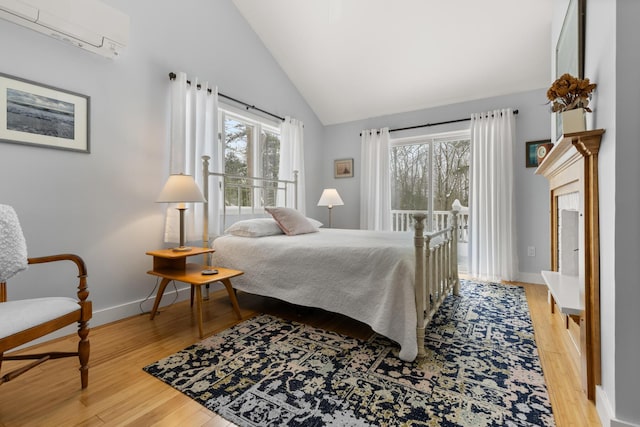 bedroom featuring vaulted ceiling, light hardwood / wood-style floors, and multiple windows