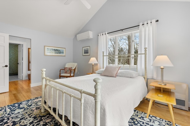 bedroom featuring ceiling fan, high vaulted ceiling, a wall unit AC, and light hardwood / wood-style flooring