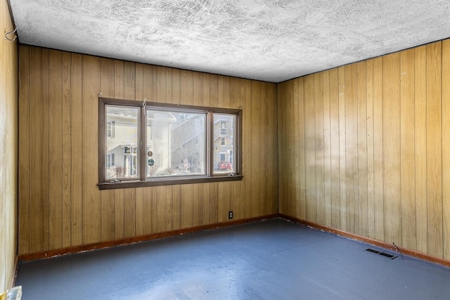 unfurnished room with a textured ceiling