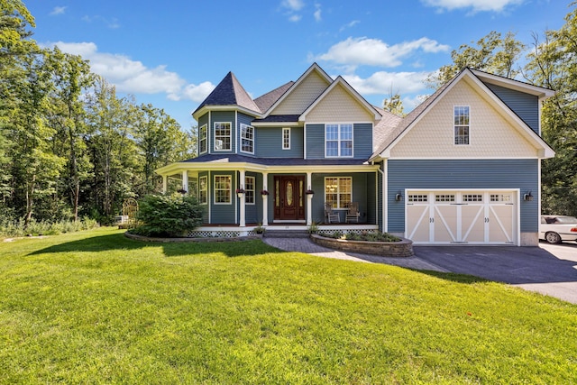 view of front of property with a porch, a garage, and a front lawn