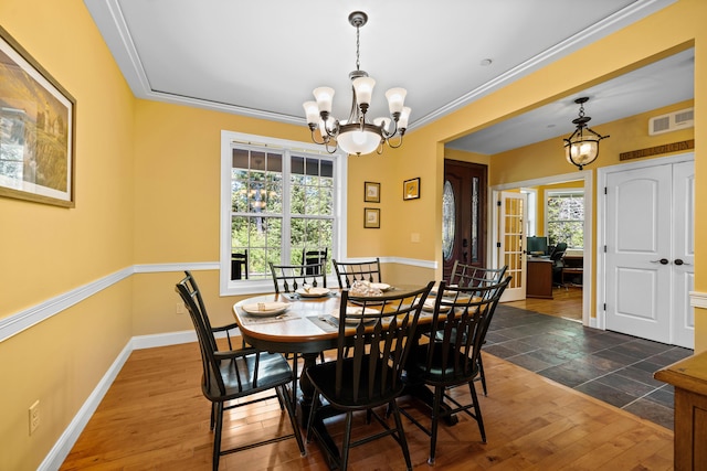 dining space with ornamental molding, dark wood-type flooring, and a notable chandelier