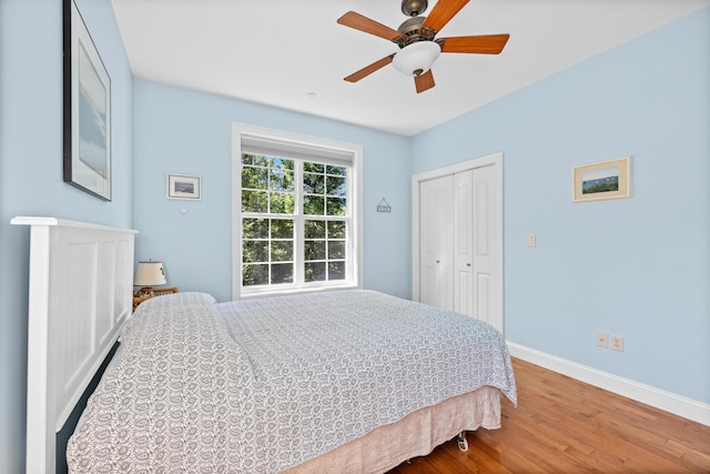 bedroom featuring wood-type flooring, ceiling fan, and a closet