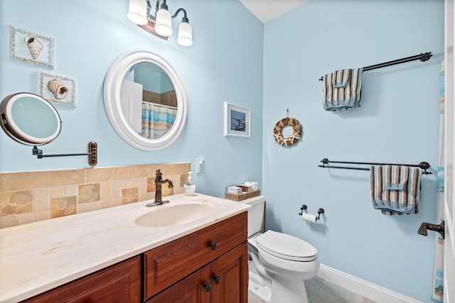 bathroom with vanity, backsplash, tile patterned flooring, and toilet