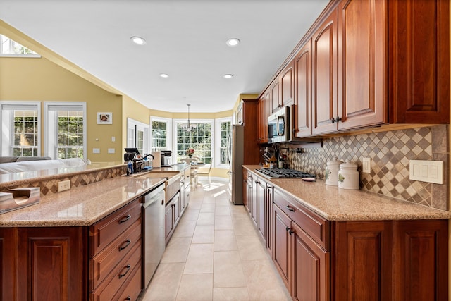 kitchen featuring light tile patterned floors, sink, appliances with stainless steel finishes, light stone counters, and decorative backsplash