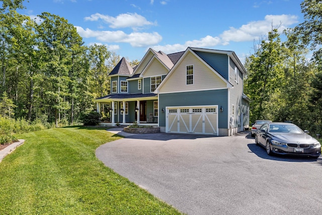 view of front of house featuring a garage, a front lawn, and covered porch