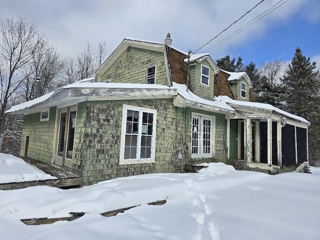 snow covered property featuring french doors