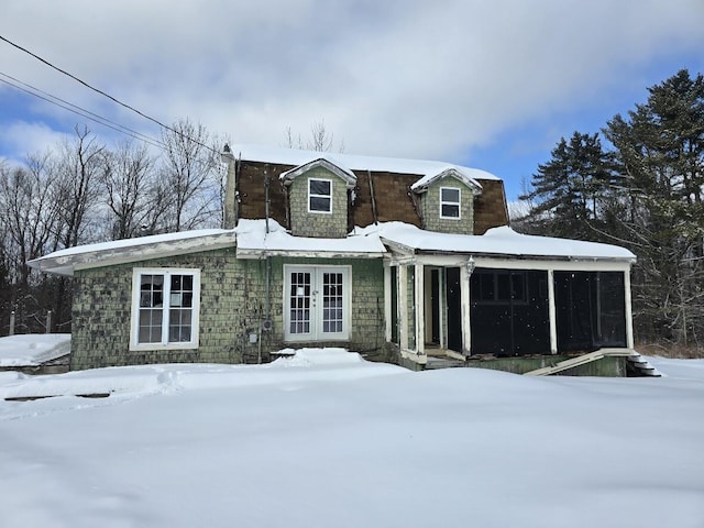 snow covered rear of property with french doors