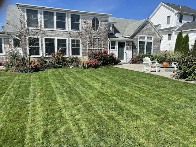 view of front of house with a patio area and a front lawn