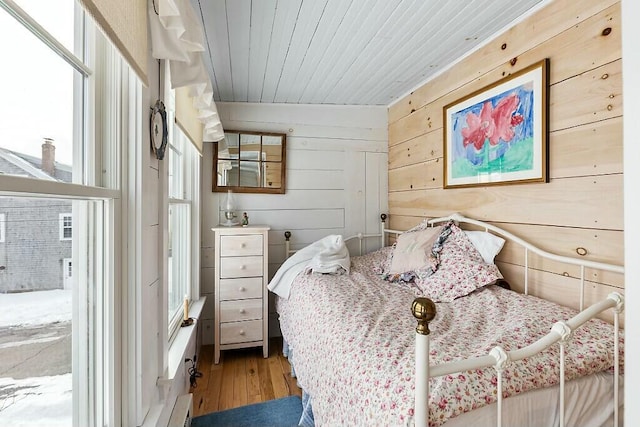 bedroom featuring wood walls, wood finished floors, and wood ceiling