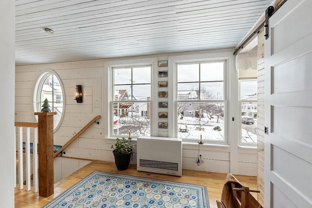 interior space with heating unit, plenty of natural light, and wood finished floors