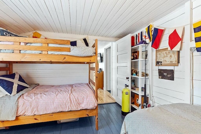 bedroom with hardwood / wood-style flooring, wood ceiling, wooden walls, and vaulted ceiling