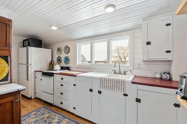 kitchen with light wood finished floors, light countertops, white appliances, and wooden ceiling