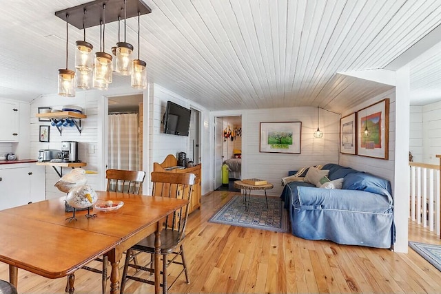 dining room with light wood-style floors, lofted ceiling, and wood ceiling