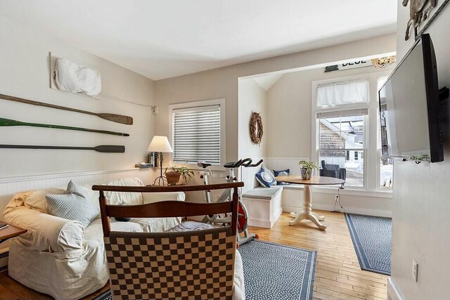 dining area with a wealth of natural light, wainscoting, and hardwood / wood-style flooring