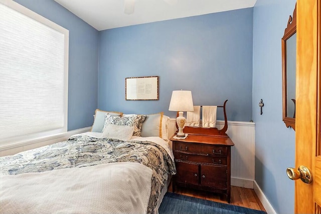 bedroom with a ceiling fan, baseboards, and wood finished floors