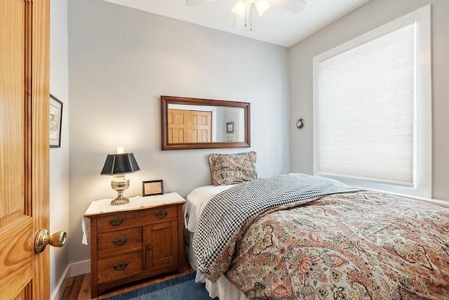 bedroom featuring ceiling fan, baseboards, and wood finished floors