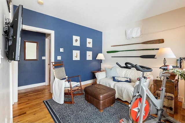 living area with baseboards and wood finished floors