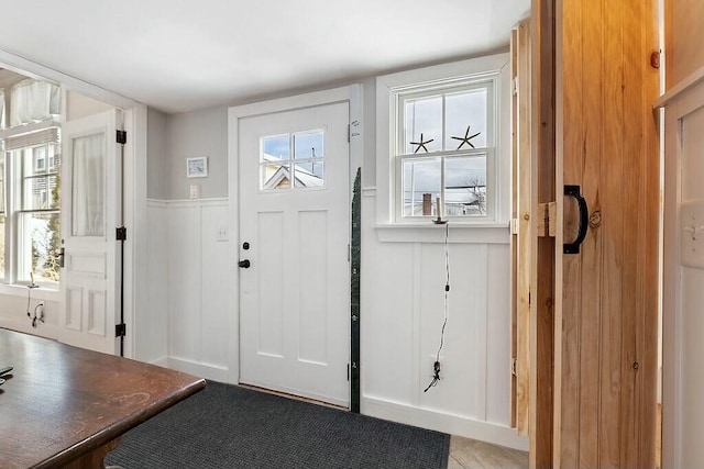 foyer entrance with a wealth of natural light and wainscoting