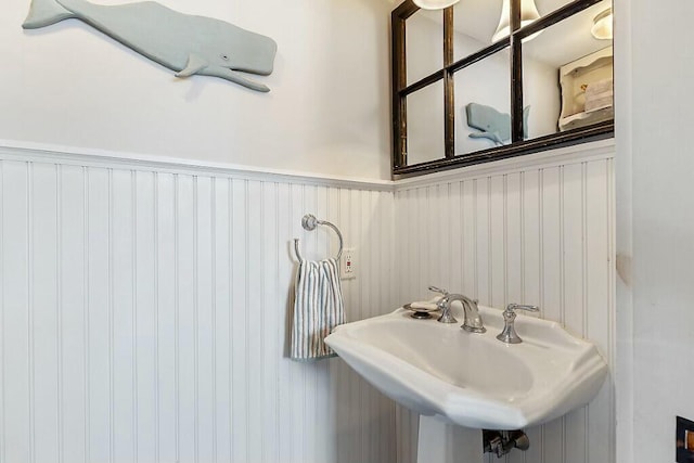 bathroom featuring a wainscoted wall and a sink