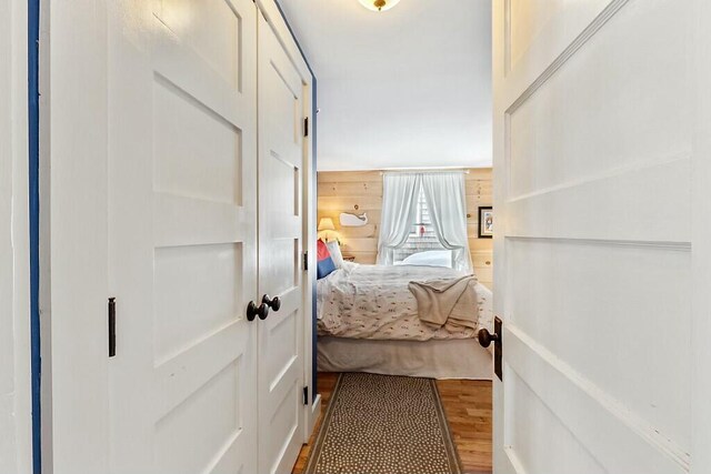 corridor featuring wood walls and wood finished floors