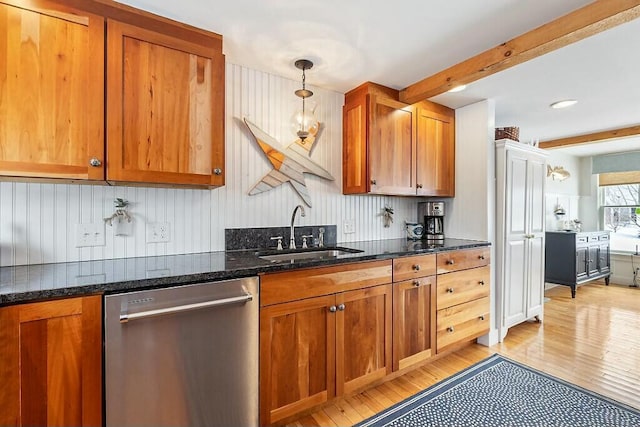 kitchen with a sink, beam ceiling, brown cabinetry, and stainless steel dishwasher