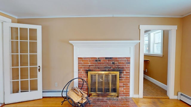 details with ornamental molding, a fireplace, wood finished floors, and a baseboard radiator