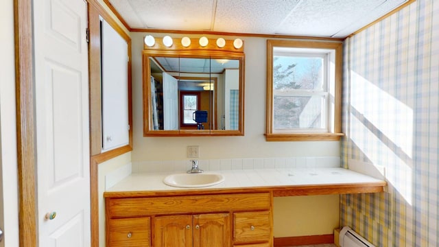 bathroom featuring baseboard heating, a textured ceiling, wallpapered walls, and vanity